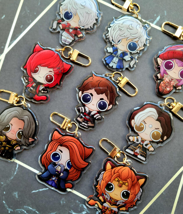 FFXIV Character Keychains photograph of 9 acrylic charms depicting alisae, alphinaud, graha, ardbert, emet selch, urianger, dulia chai, and wuk lamat