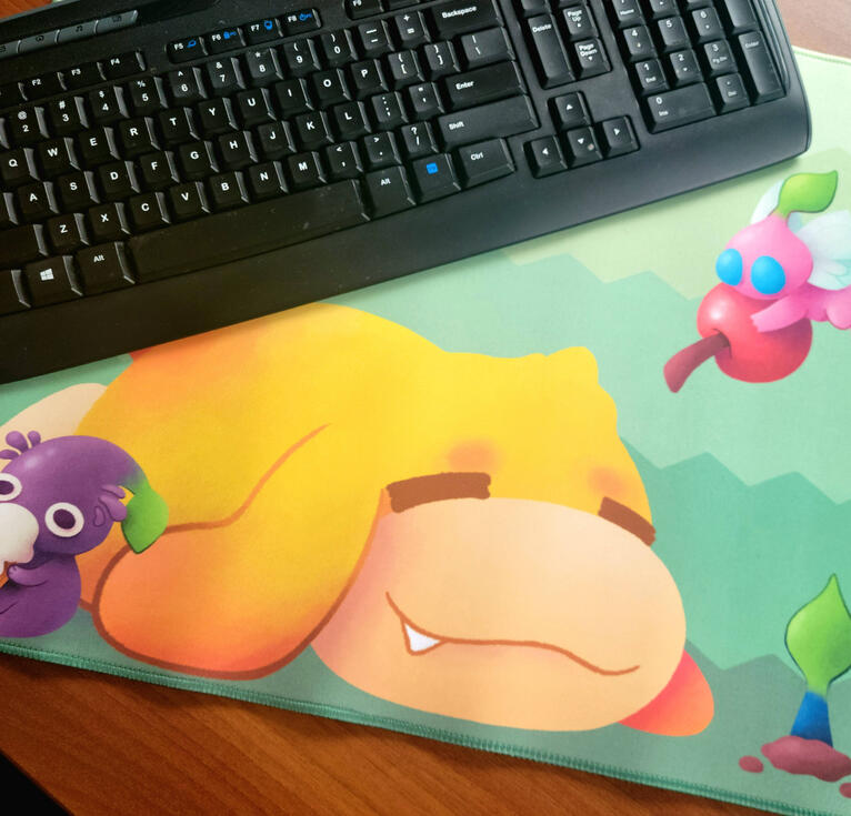 Pikmin Deskmat photograph of a desk mat depicting oatchi from pikmin, a purple pikmin eating an icecream and a winged pikmin carrying a cherry